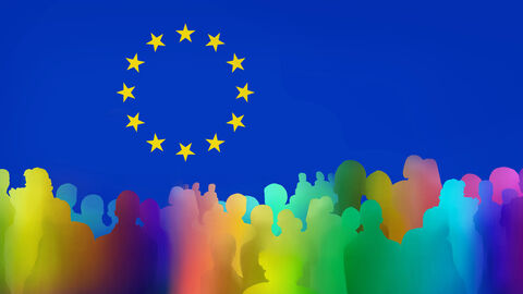 Europasymbol aus 12 gelben Sterne kreisförmig auf blauem Untergrund mit bunter Menschensilhouette im Vordergrund 